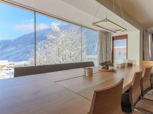 a dining room with a large table and a large window at Luxurious Holiday Home in Krimml with Sauna in Krimml +66 photos