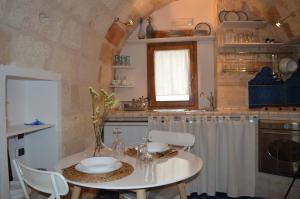 una cucina con tavolo, sedie e lavandino di G.H.03 Polignano a Mare a Polignano a Mare