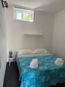 a bedroom with a bed with a blue and green blanket at Tosk House in Peschici