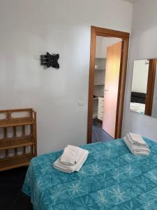 a room with a bed with towels on it at Tosk House in Peschici
