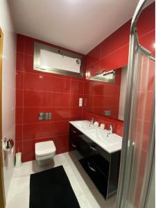 Un baño rojo con inodoro y lavabo. en Nazaré Luxury Villa with Private Pool, en Nazaré