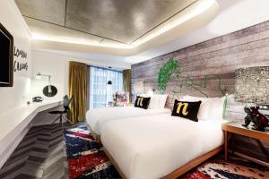 a hotel room with two beds and a brick wall at nhow London in London +90 photos