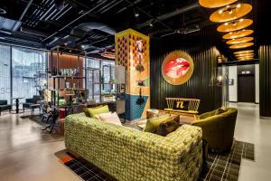a room with a couch and chairs in it at nhow London in London