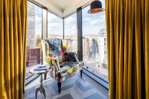 a chair in a room with a large window at nhow London in London