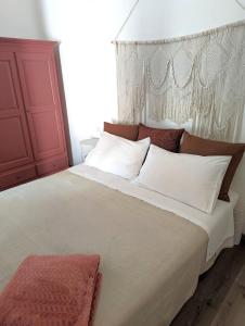 a bedroom with a large white bed with a red cabinet at Dimora Tauro B&B in Fasano