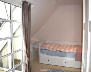 a bedroom with a bed next to a window at Leo-s-Hues in Tinnum