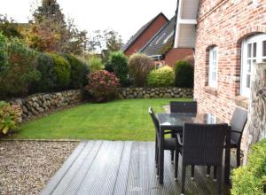 a patio with a table and chairs in a yard at Leo-s-Hues in Tinnum