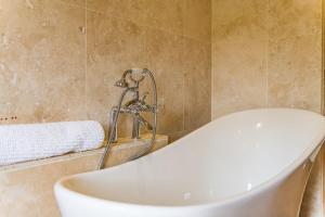 a bath tub in a bathroom with a shower at Pond Cottage by Keepers Cottages in Egerton +24 photos
