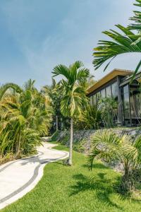 a palm tree in front of a house at Soul Spring Sanctuary Cuernavaca in Xochitepec