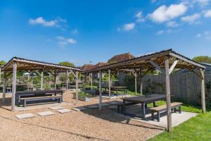 a group of picnic tables in a park at Pond Cottage by Keepers Cottages in Egerton