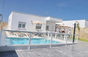 a villa with a swimming pool in front of a house at El Rincon de Samuel in Conil de la Frontera