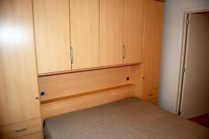 a small bedroom with wooden cabinets and a bed at Residentie Hof van Vlaanderen in Nieuwpoort