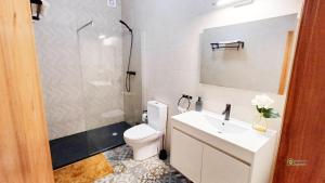 a bathroom with a white toilet and a sink at Apartamento acolhedor no coração da cidade in Angra do Heroísmo +6 photos