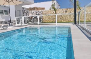 a swimming pool with blue water in a building at El Rincon de Samuel in Conil de la Frontera