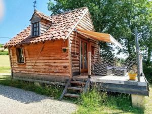 a wooden cabin with a porch and a fence at La Plaisance sur Ciel in Cordes-sur-Ciel
