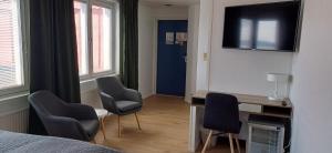 ein Schlafzimmer mit zwei Stühlen, einem Schreibtisch und einem Bett in der Unterkunft Hotel Kalkstrand in Pargas