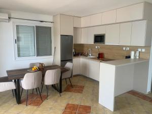 a kitchen with a wooden table and chairs and a counter at un site calme et unique au Montenegro Loue des logements les pieds dans l eau avec plage privée en face de l ile Saint Marco in Tivat