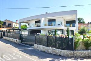 a large white house with a black fence at Villa Sarah in Vantačići