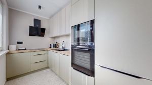 a kitchen with white cabinets and a refrigerator at FLEXIHOME sk - SNP 7 - four room apartment, AC, loggia in Košice