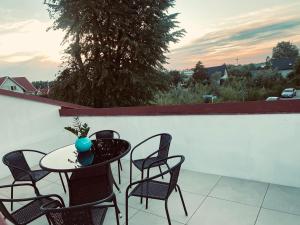 a table and chairs on a balcony with a view at Apartament Turkusowy in Puck