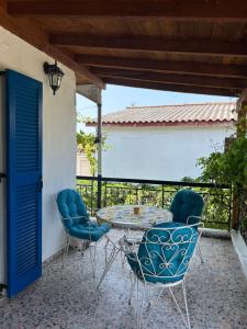 a patio with a table and chairs on a balcony at 600 metres from the beach! in Nea Irakleia
