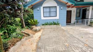 a blue house with a walkway in front of it at The Village - Ella in Bandarawela