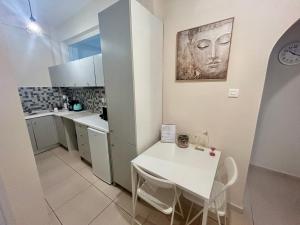 a kitchen with a white table and a white counter top at AKTIS apartment 4 near airport in Artemida +9 photos