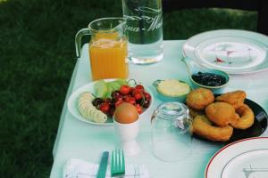 a white table with a plate of food and orange juice at Guest House Adi Hoxha in Berat