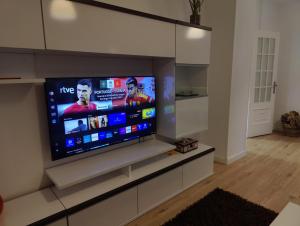 a large flat screen tv in a living room at Ático espacioso en zona céntrica in Sarria