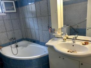 a bathroom with a bath tub and a sink at 600 metres from the beach! in Nea Irakleia +7 photos