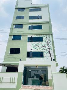 a tall building with a tree painted on it at Hotel Vistaara Grand in Guntūr