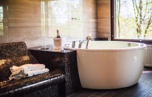 a bathroom with a large tub and a chair at Hotel Haikko Manor & Spa in Porvoo