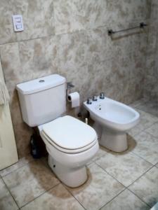 ein Badezimmer mit einer weißen Toilette und einem Waschbecken in der Unterkunft Alojamiento LUNNA in Río Grande + 4 Fotos