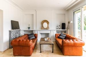 a living room with two leather couches and a table at Large villa near beach, sea view, islands & bay of Cannes, 7 bedrooms in Cannes