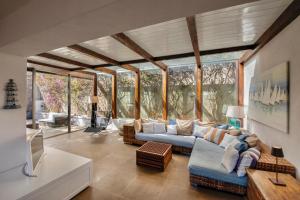 un salon avec un canapé et des murs en verre dans l'établissement [porto ercole] comfort vista mare + parcheggio gratuito, à Cala Galera