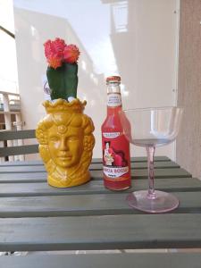 a table with a bottle of hot sauce and a glass at Ortocastello Comfort Rooms in Gela
