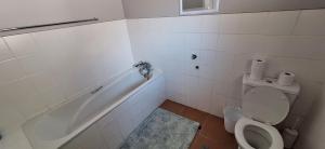 a bathroom with a tub and a toilet and a sink at Firehouse selfcatering Garden Cottages no 5 in Wellington +13 photos