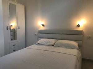 a bedroom with a bed with two pillows and two lights at un site calme et unique au Montenegro Loue des logements les pieds dans l eau avec plage privée en face de l ile Saint Marco in Tivat