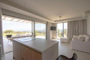 eine Küche und ein Wohnzimmer mit einer Couch und einem Tisch in der Unterkunft The Quiet Pearl Villa, Agios Nikolaos by Halkidiki Villas in Agios Nikolaos