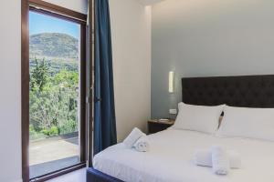 a bedroom with a bed and a window with a view at Villa Athina Corfu - 4 bedrooms in Kynopiástai +43 photos