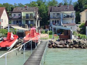 a dock with a boat on the water next to houses at Apartment in Siófok 19919 in Siófok