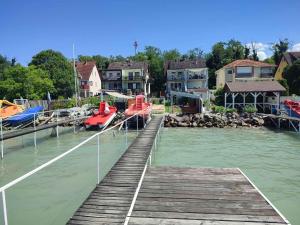 a dock with a boat in the water next to houses at Apartment in Siófok 19919 in Siófok
