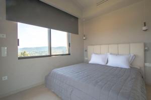 ein Schlafzimmer mit einem großen Bett mit einem großen Fenster in der Unterkunft The Quiet Pearl Villa, Agios Nikolaos by Halkidiki Villas in Agios Nikolaos + 20 Fotos