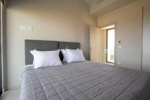 ein Schlafzimmer mit einem großen Bett und weißen Kissen in der Unterkunft The Quiet Pearl Villa, Agios Nikolaos by Halkidiki Villas in Agios Nikolaos