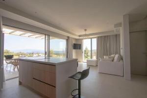 eine Küche und ein Wohnzimmer mit einer Couch und einem Tisch in der Unterkunft The Quiet Pearl Villa, Agios Nikolaos by Halkidiki Villas in Agios Nikolaos