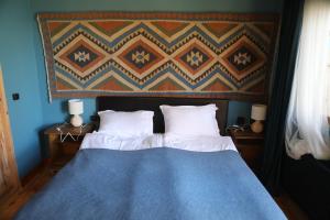 a bedroom with a blue bed with two pillows at Lurji Bani in Sighnaghi