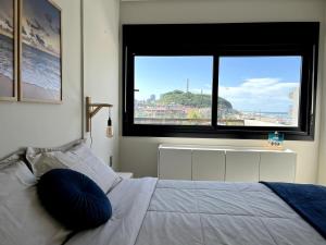 a bedroom with a bed with a large window at Apartment by the sea Torres Parque da Guarita in Torres