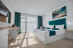 a bedroom with a large bed with a blue headboard at Complex Sea Star 2Mai in 2 Mai
