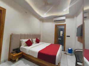 ein Schlafzimmer mit einem großen Bett und roten Kissen in der Unterkunft Hotel Venzaa Vijay Nagar in Indore