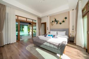 a bedroom with a large bed and a couch at Ocean Palms Private Pool Villas in Ban Thalat Choeng Thale